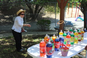 A participant throwing a ring on top of bottles 