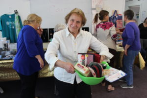 A participant posing with her prize, a basket of various items 